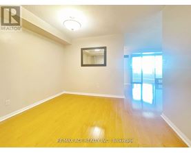 A room with a wooden floor and a mirror on the wall.