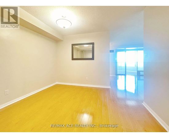 A room with a wooden floor and a mirror on the wall.