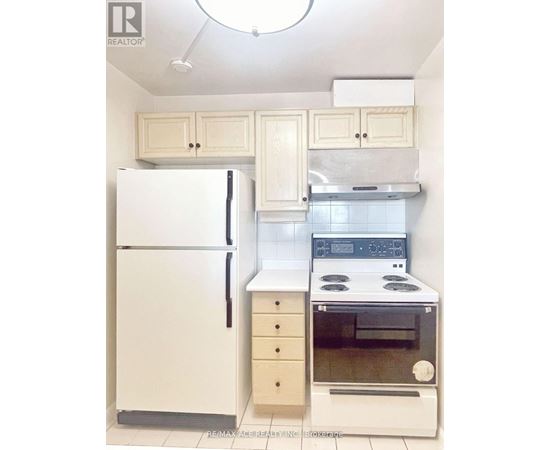 A white refrigerator and oven in a kitchen.