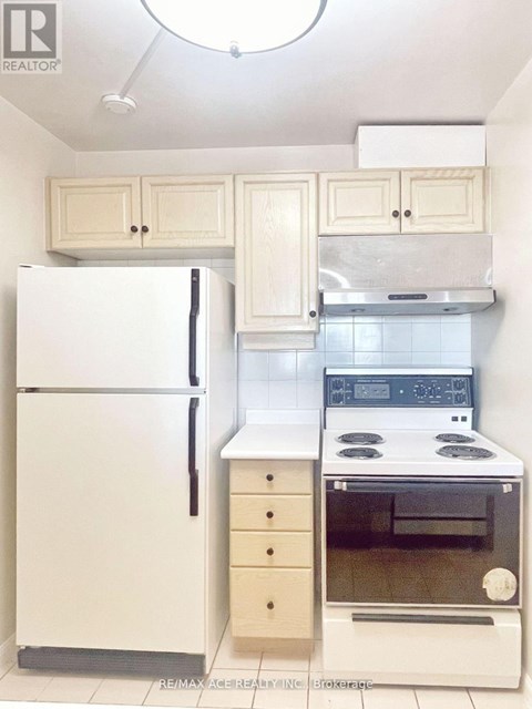 A white refrigerator and oven in a kitchen.