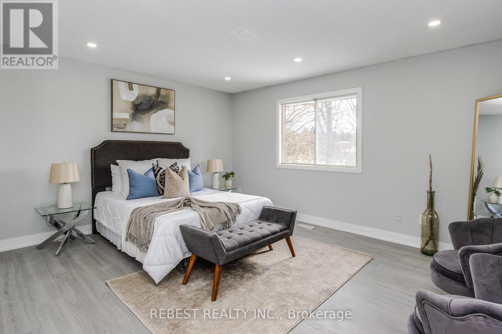 A bedroom with a large bed and a chair.