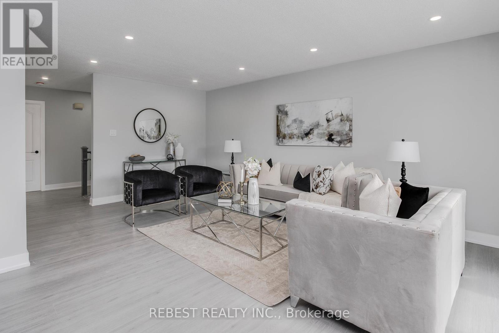 A modern living room with a white sofa and a glass coffee table.