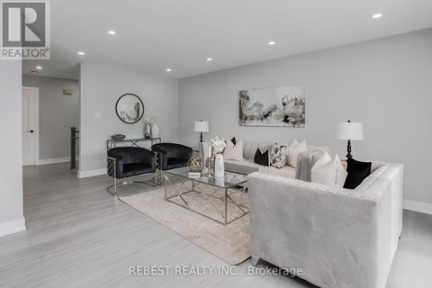 A modern living room with a white sofa and a glass coffee table.
