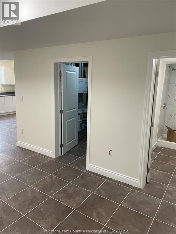 A room with a tiled floor and a doorway leading to another room.
