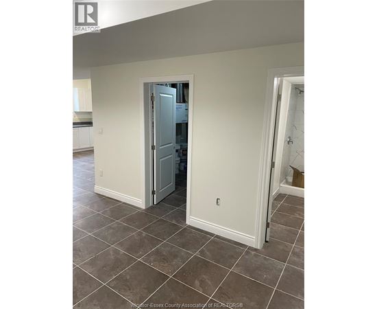 A room with a tiled floor and a doorway leading to another room.