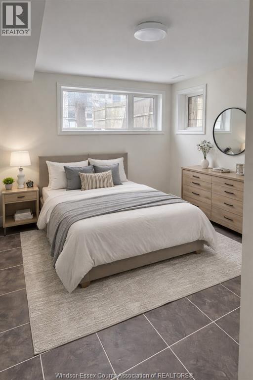 A bedroom with a bed, nightstand, and a mirror.