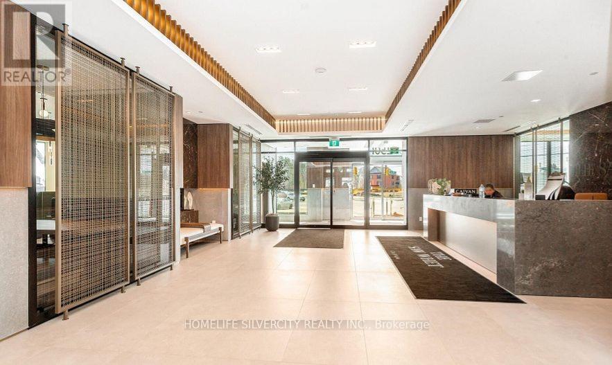 A modern lobby with a reception desk and glass doors.