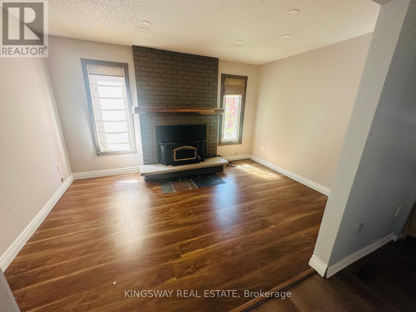 A living room with a fireplace and wood flooring.