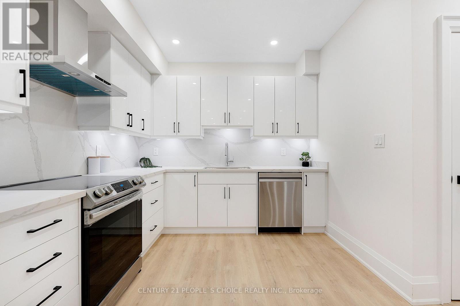 A kitchen with white cabinets and a black stove top oven.