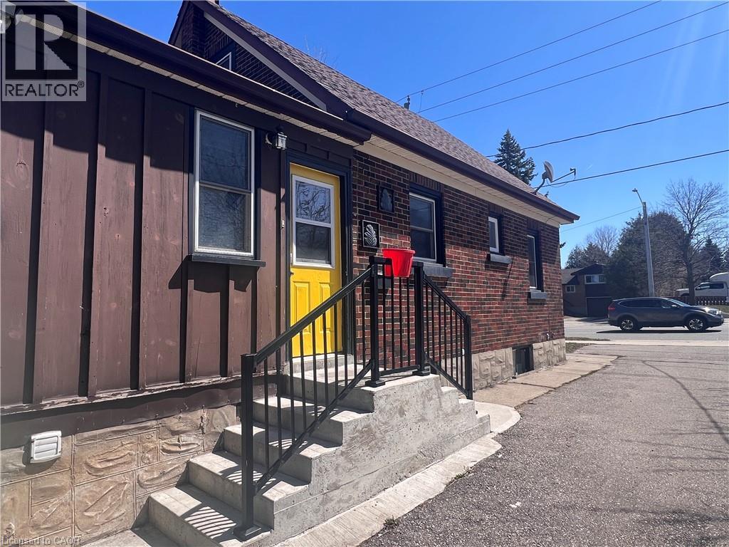 A house with a yellow door and a black railing on the stairs.