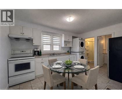 A well-lit kitchen with a dining table set for two.