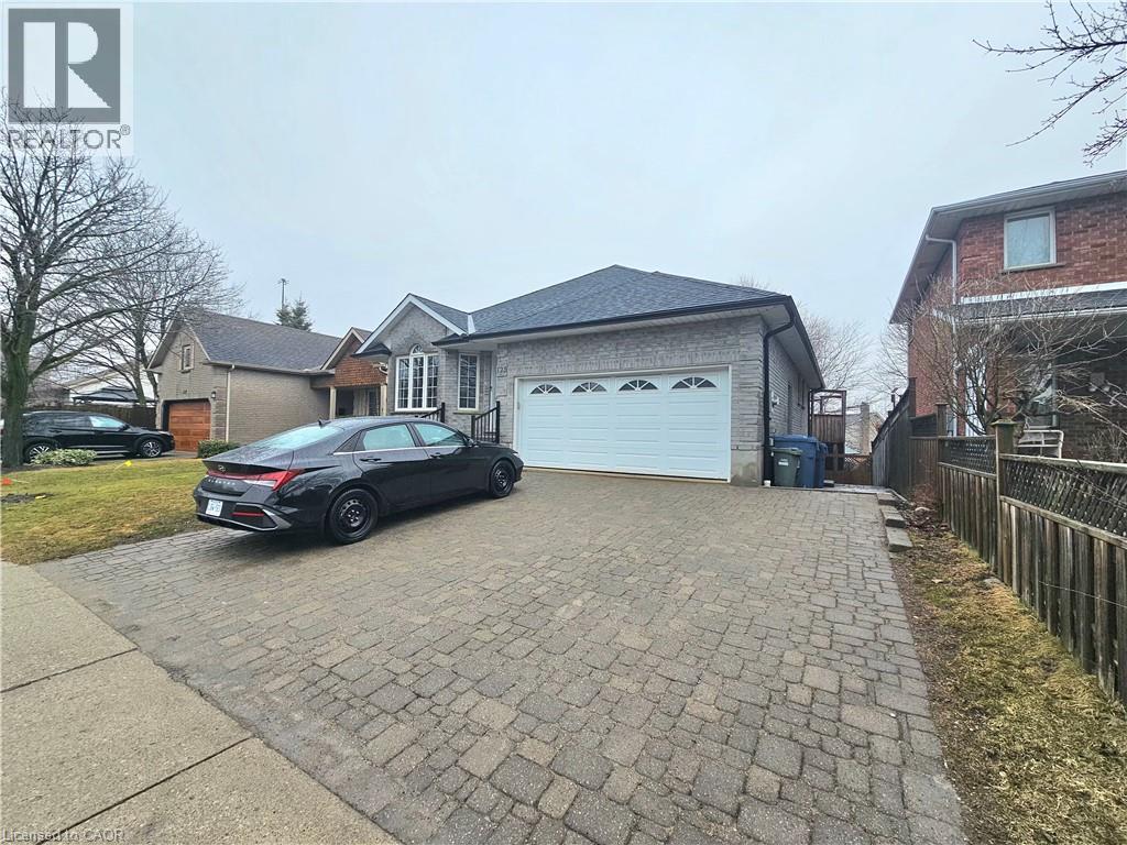 A car is parked in front of a house with a garage.