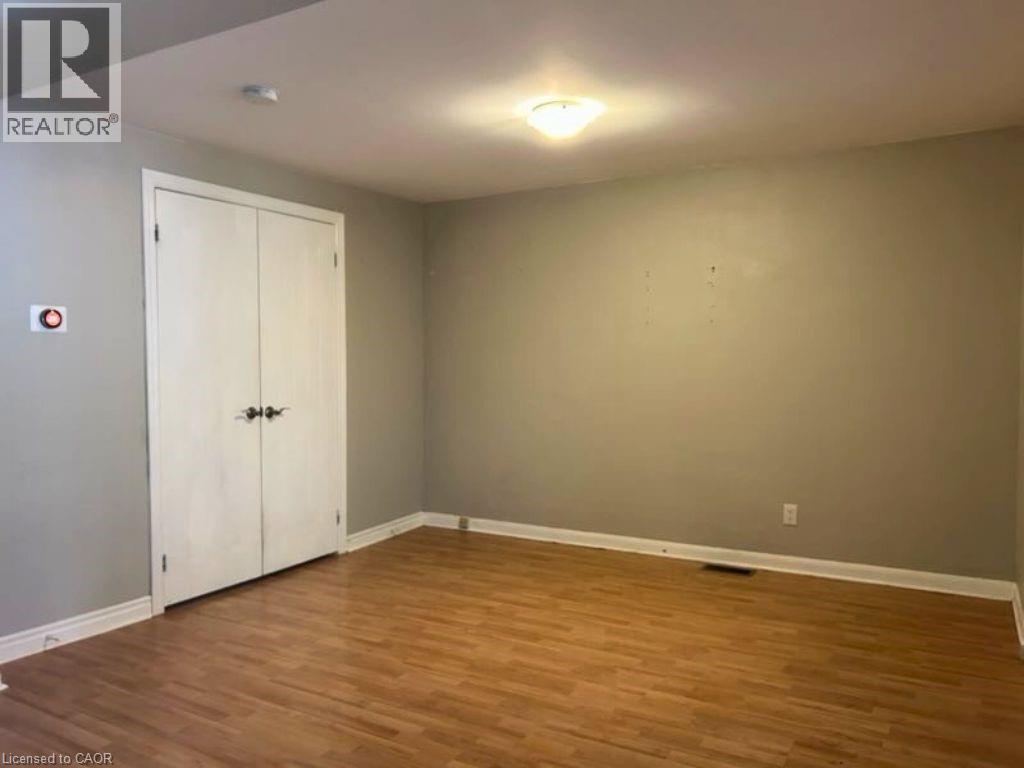 A room with a white door and wooden flooring.