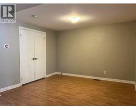 A room with a white door and wooden flooring.