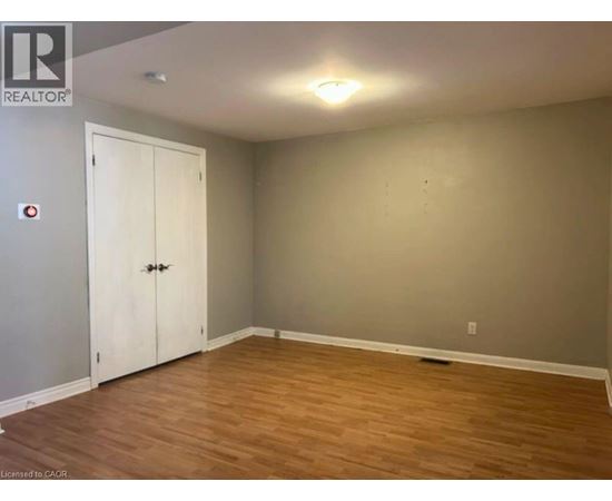 A room with a white door and wooden flooring.