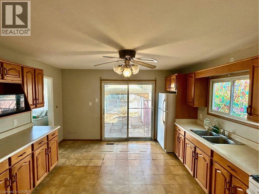 A kitchen with wooden cabinets and a ceiling fan.