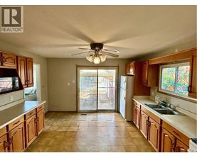 A kitchen with wooden cabinets and a ceiling fan.