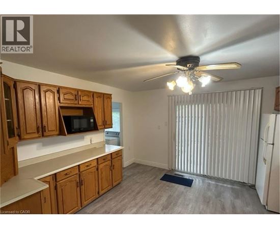 A kitchen with wooden cabinets and a ceiling fan.