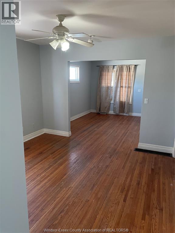 A room with wooden floors and a ceiling fan.