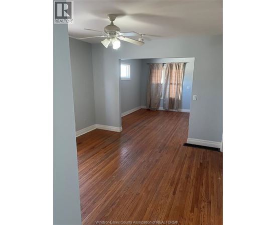 A room with wooden floors and a ceiling fan.