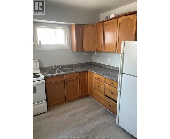 A kitchen with wooden cabinets and a white fridge.