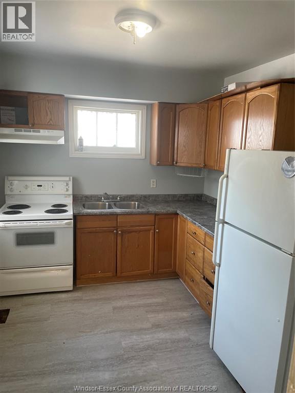 A kitchen with a white fridge, stove and oven.