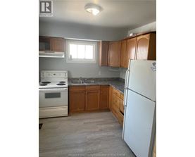 A kitchen with a white fridge, stove and oven.
