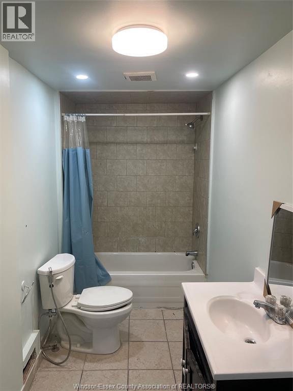 A bathroom with a toilet, sink, and bathtub.