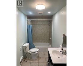 A bathroom with a toilet, sink, and bathtub.