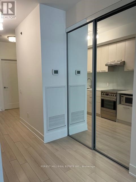 A modern kitchen with a white refrigerator and wooden flooring.