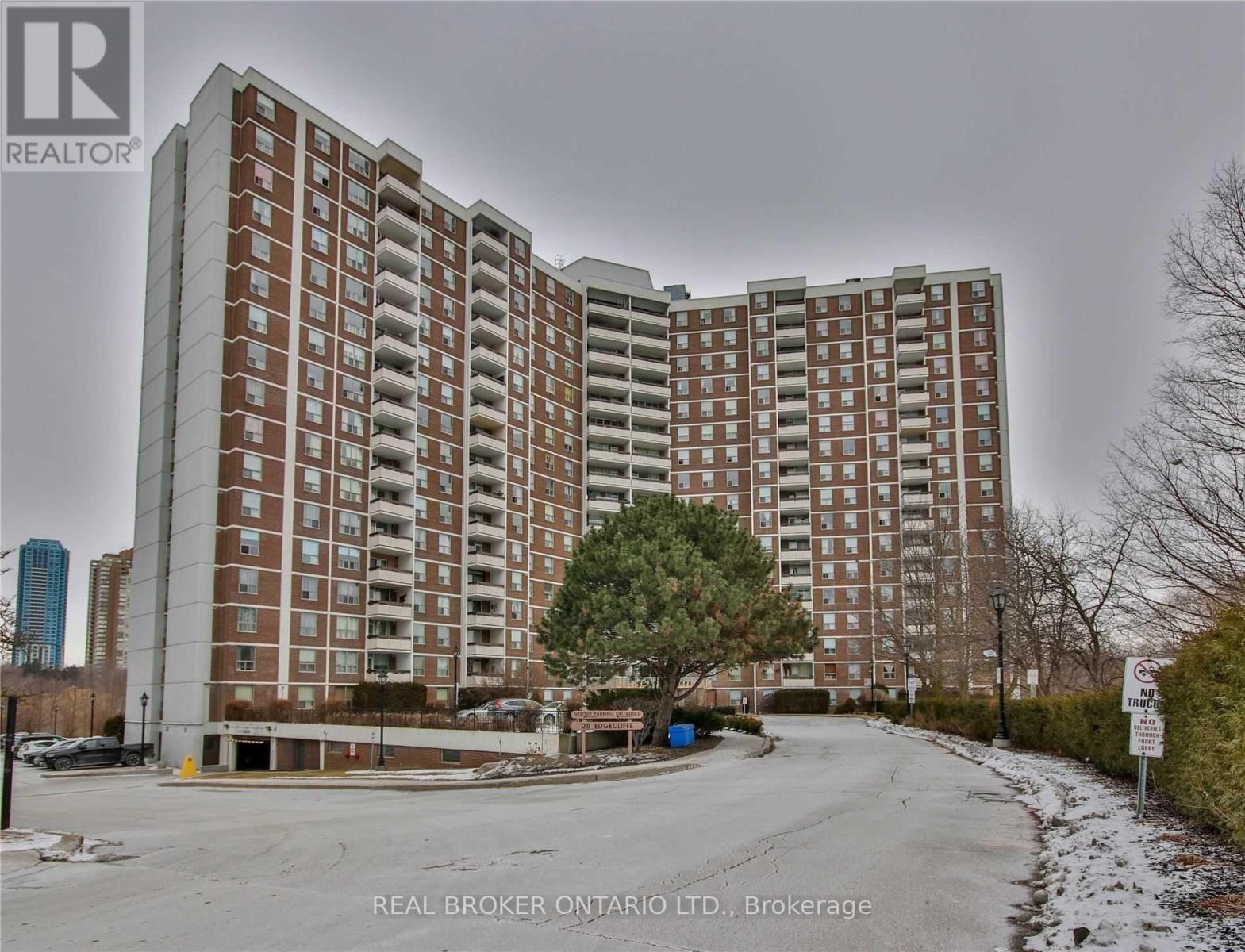A tall apartment building with a tree in front of it.