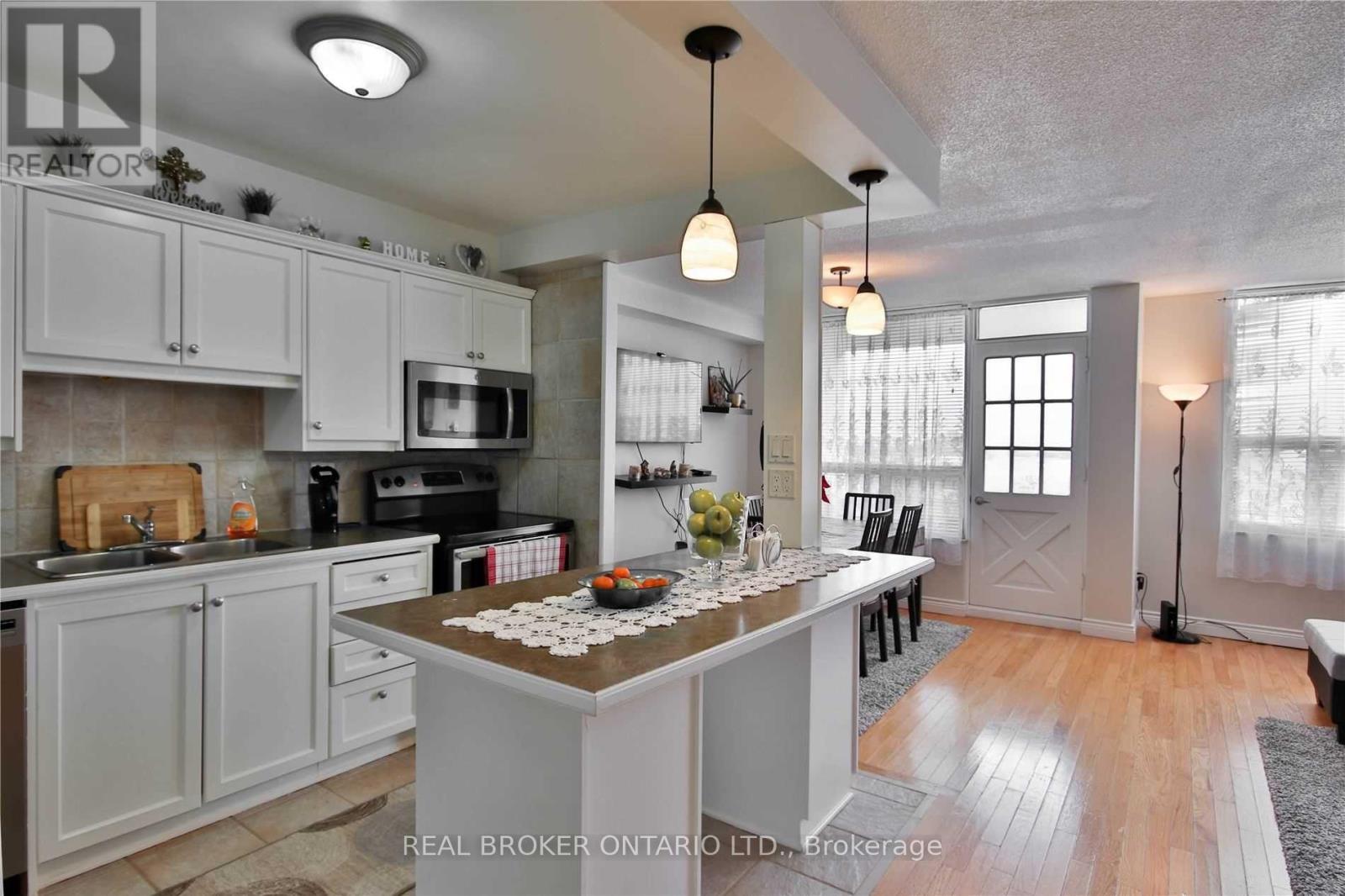 A kitchen with white cabinets and a wooden island.