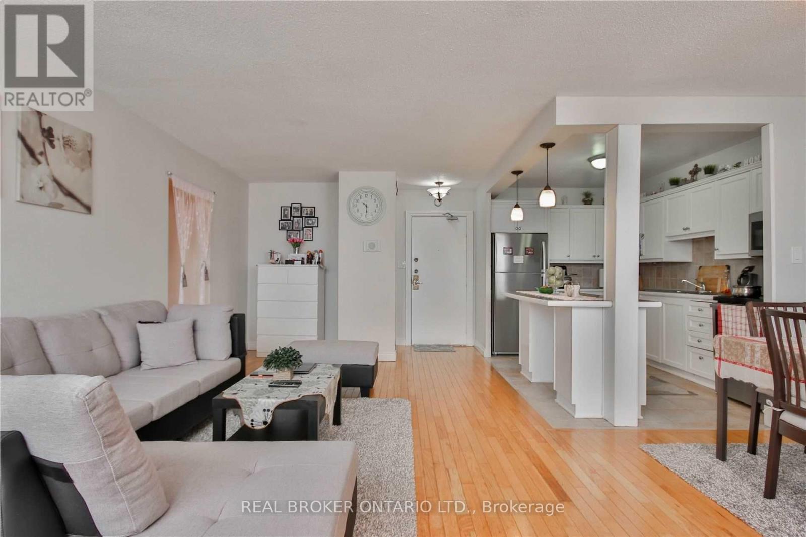 A well-lit, spacious living room with a grey sofa and a coffee table.