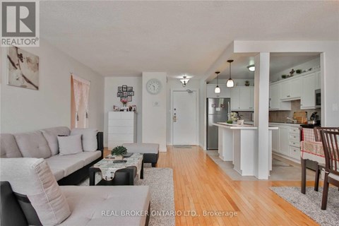 A well-lit, spacious living room with a grey sofa and a coffee table.