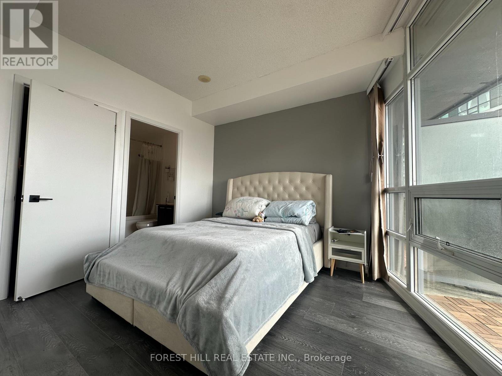A bedroom with a large bed and a sliding glass door.