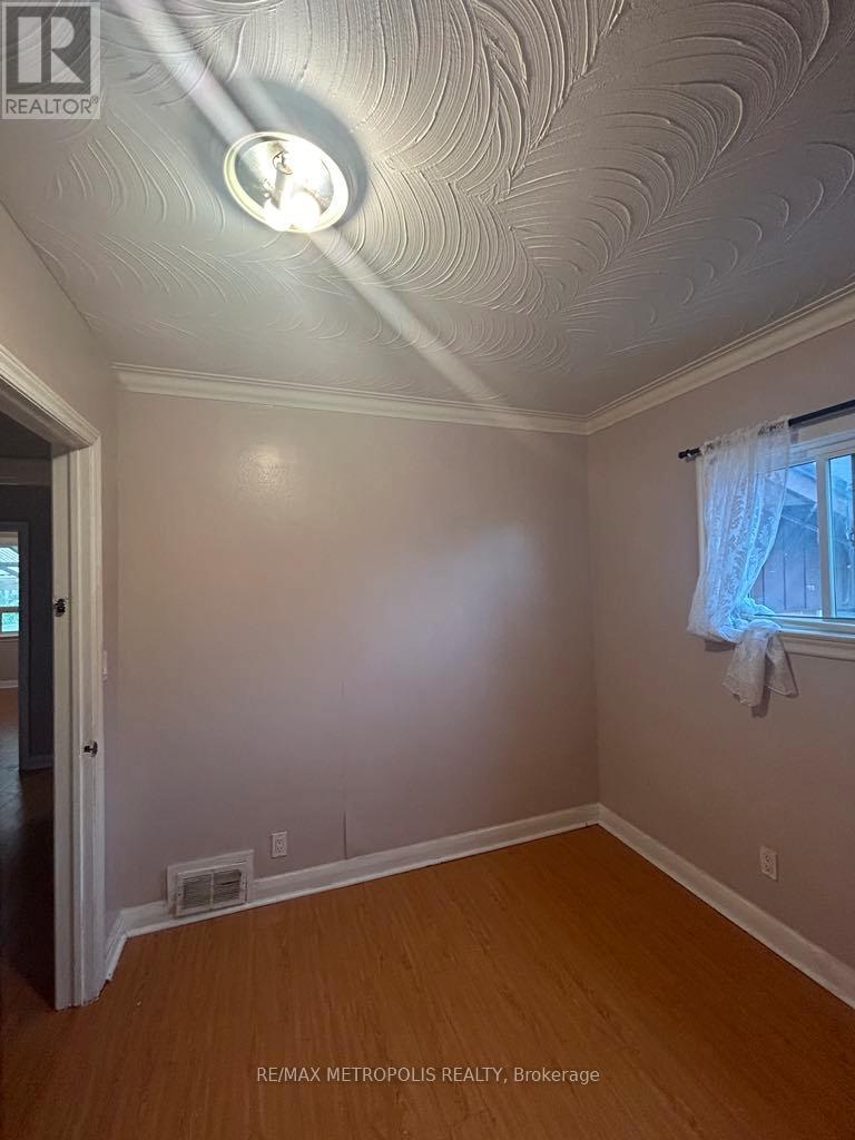A room with a ceiling light and a window with curtains.