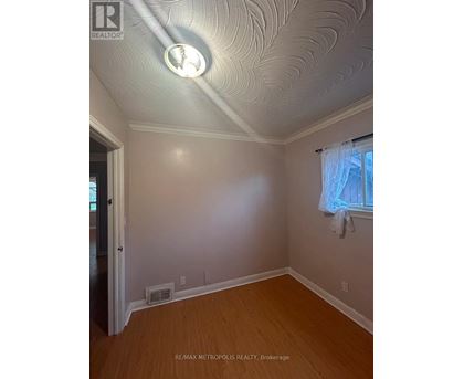 A room with a ceiling light and a window with curtains.