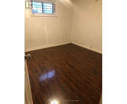 A room with a wooden floor and a window.