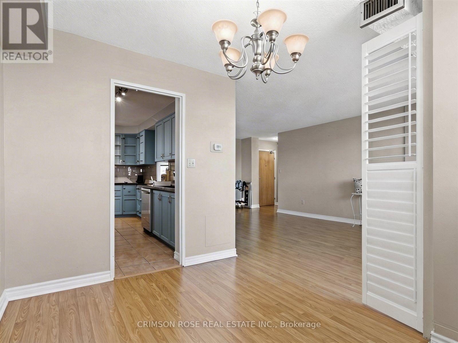 A realtor photo of a room with a kitchen in the background.