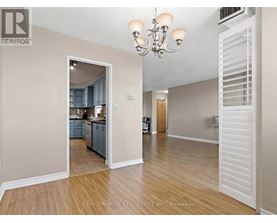A realtor photo of a room with a kitchen in the background.