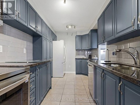 A kitchen with dark blue cabinets and a white refrigerator.