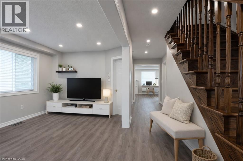 A living room with a television and a staircase.
