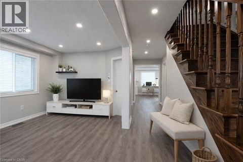 A living room with a television and a staircase.
