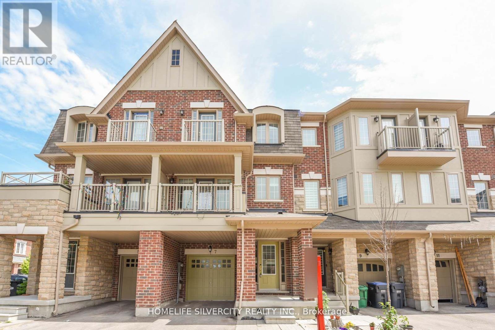 A large, multi-story residential building with a balcony on the second floor.