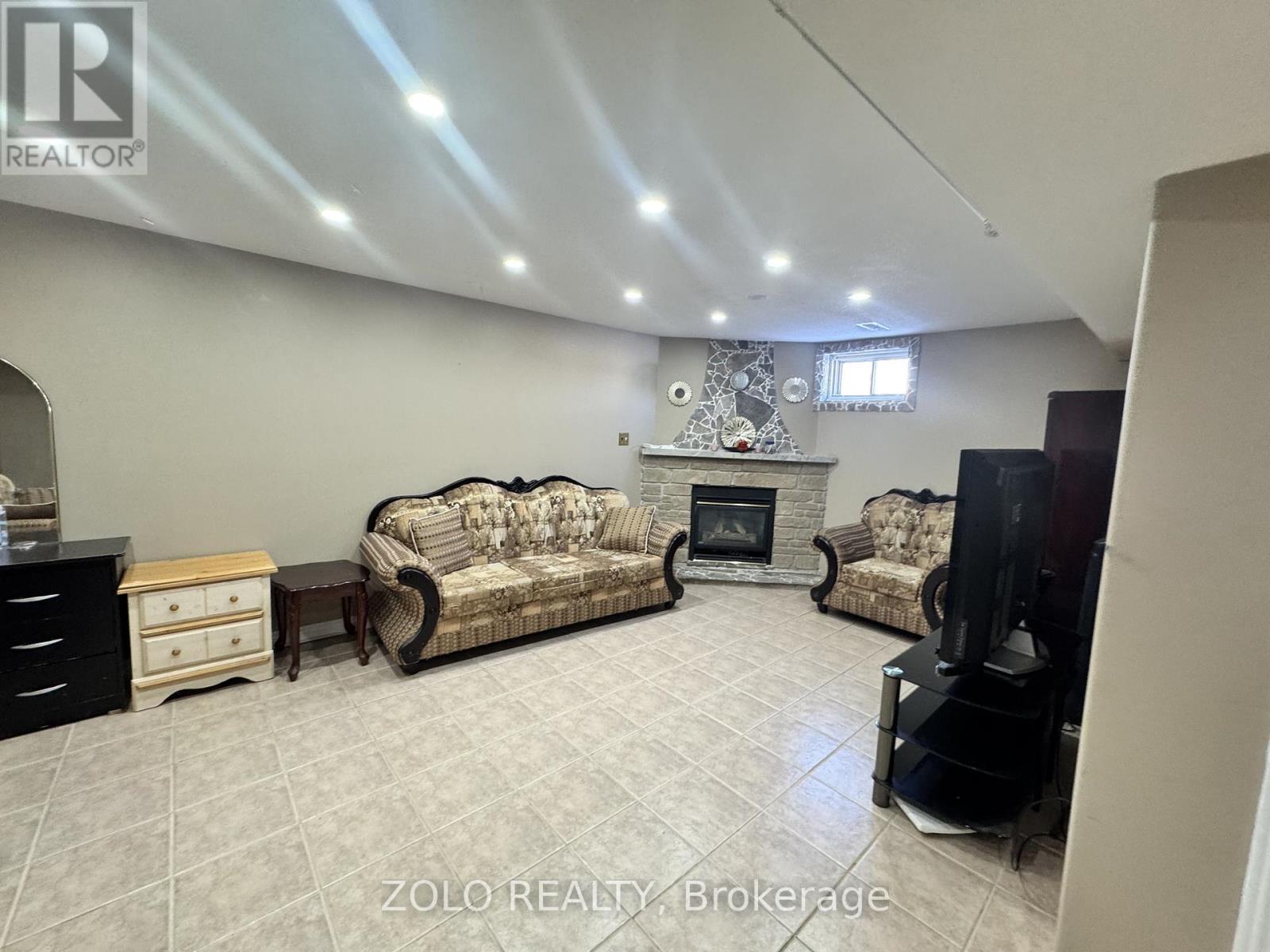 A living room with a fireplace and two couches.
