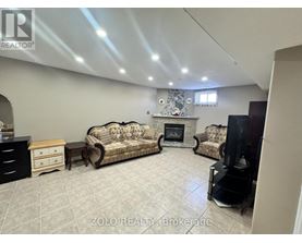 A living room with a fireplace and two couches.