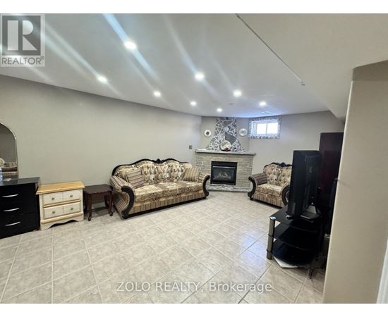 A living room with a fireplace and two couches.