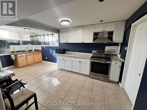 A kitchen with white cabinets and a blue backsplash is for sale.