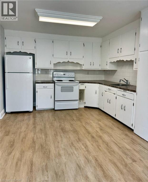 A kitchen with white appliances and cabinets.