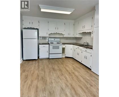 A kitchen with white appliances and cabinets.